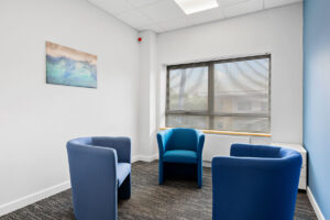 Small assessment and therapy room with two chairs and a low table